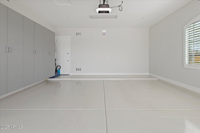 garage with a garage door opener and visible vents