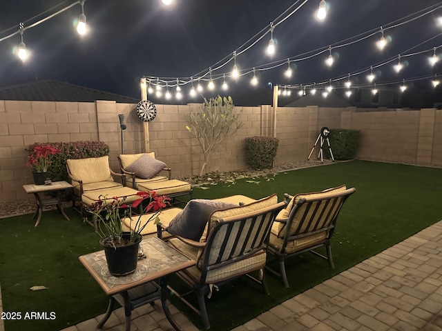 patio at twilight with a fenced backyard and an outdoor hangout area