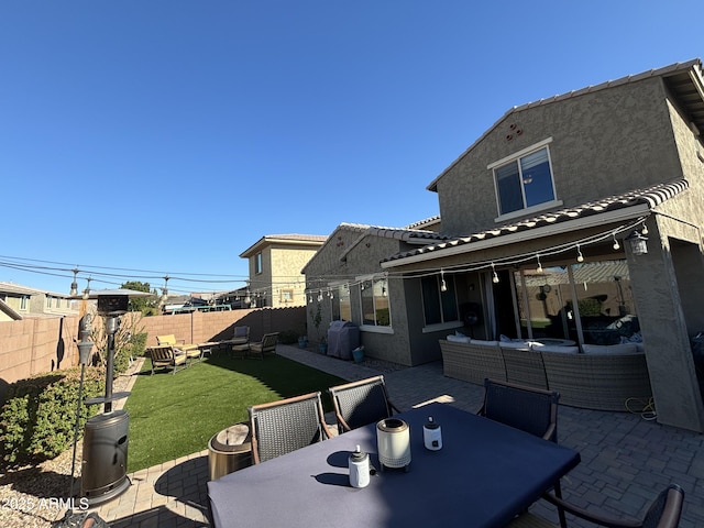 back of house featuring a lawn, a patio, outdoor dining space, outdoor lounge area, and stucco siding