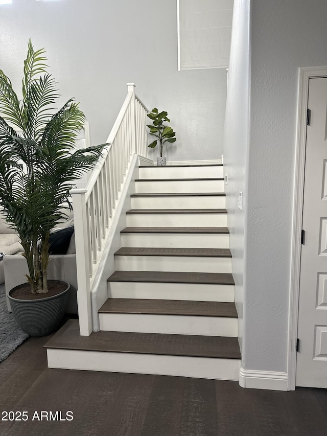 stairs featuring baseboards and wood finished floors