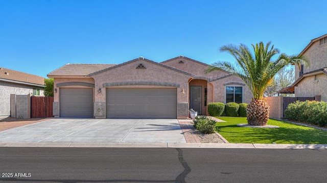 mediterranean / spanish home featuring concrete driveway, an attached garage, and fence