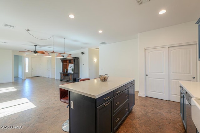 kitchen with visible vents, recessed lighting, a kitchen island, and light countertops