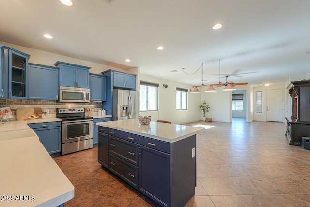 kitchen featuring decorative backsplash, appliances with stainless steel finishes, open floor plan, and light countertops