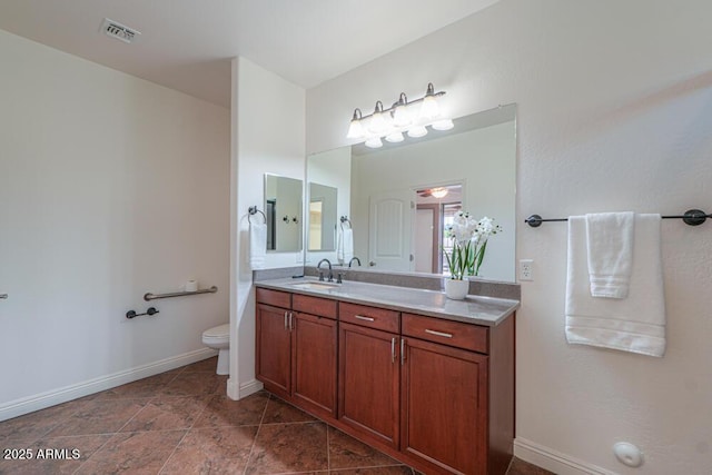 bathroom featuring vanity, toilet, baseboards, and visible vents