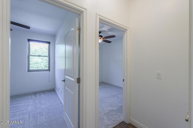 corridor featuring carpet flooring and baseboards