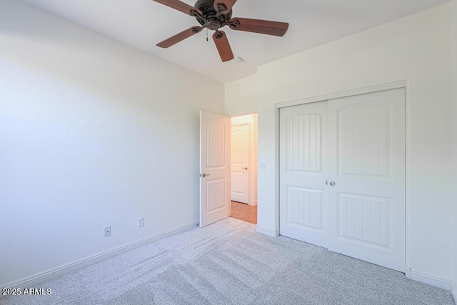 unfurnished bedroom with a closet, baseboards, carpet, and ceiling fan