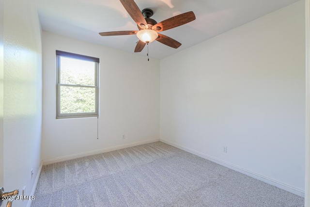 spare room featuring baseboards, light colored carpet, and a ceiling fan