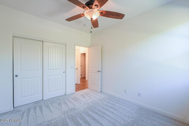 unfurnished bedroom featuring a closet, carpet flooring, ceiling fan, and baseboards