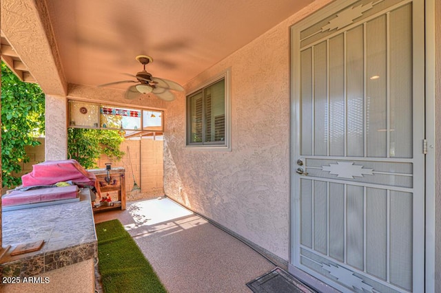 view of patio with ceiling fan and fence