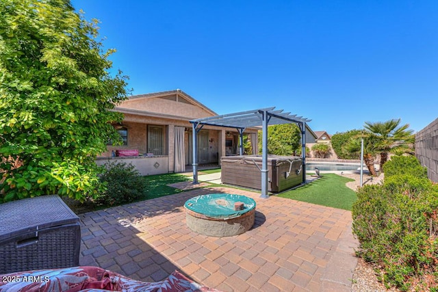 view of patio with a pergola, a hot tub, and fence