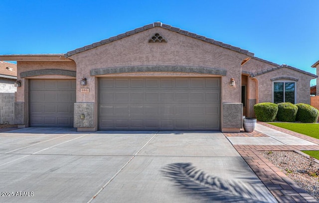 view of front of property featuring stucco siding, concrete driveway, and an attached garage