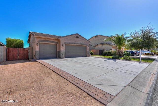 view of front of property with stucco siding, a gate, fence, concrete driveway, and a garage