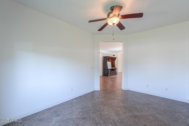 unfurnished room with baseboards and a ceiling fan