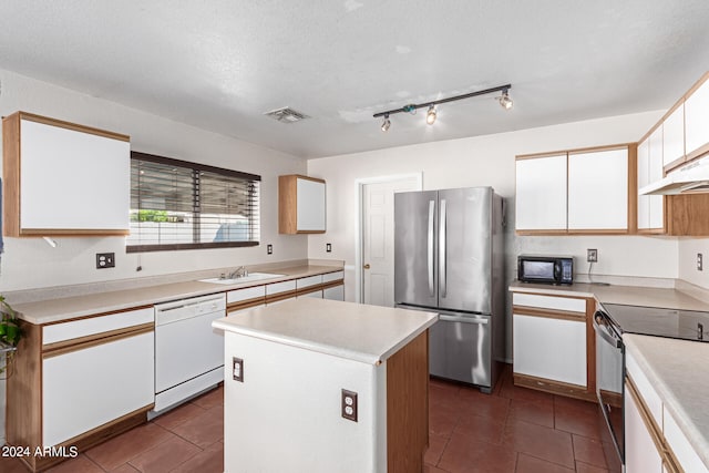 kitchen with white cabinets, appliances with stainless steel finishes, a center island, and a textured ceiling