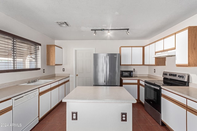 kitchen with white cabinets, a textured ceiling, appliances with stainless steel finishes, and a kitchen island