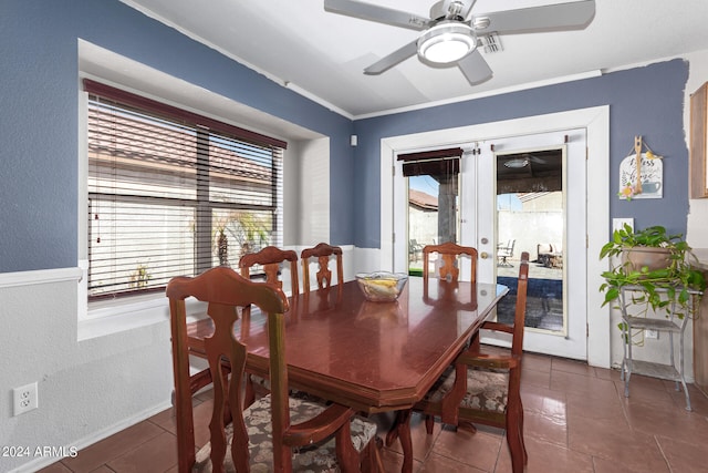 tiled dining space with ceiling fan, crown molding, and french doors