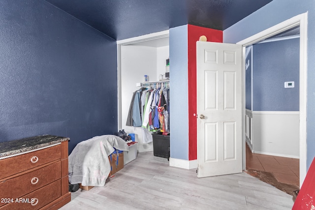 bedroom with a closet and light hardwood / wood-style flooring