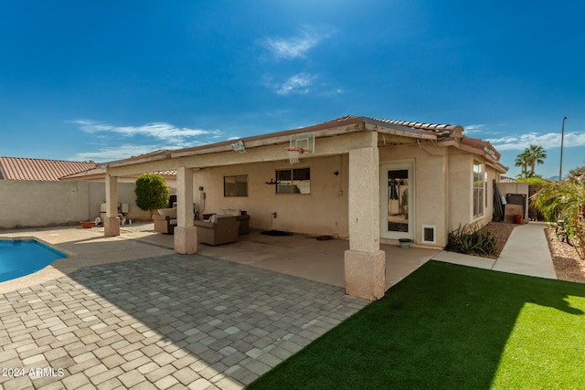 rear view of house featuring a fenced in pool, a patio, and a lawn