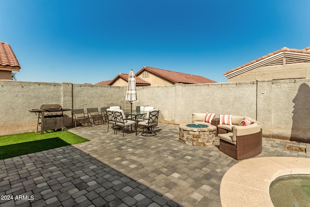 view of patio with a grill and an outdoor living space with a fire pit