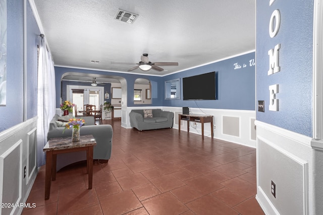 living room with ceiling fan and a textured ceiling