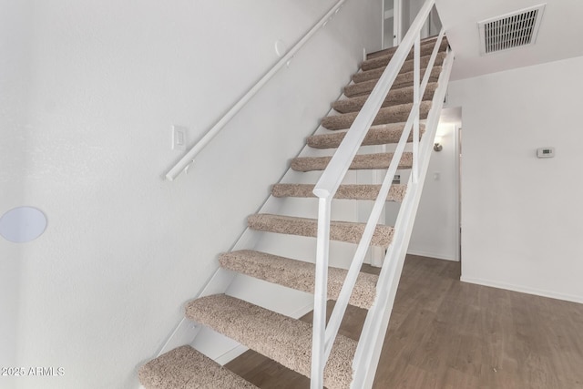 stairway with hardwood / wood-style floors