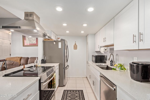 kitchen featuring sink, island range hood, light tile patterned floors, appliances with stainless steel finishes, and white cabinets