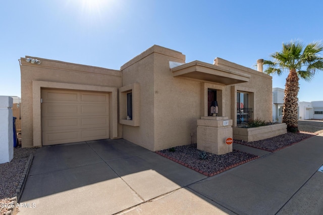 pueblo revival-style home featuring a garage