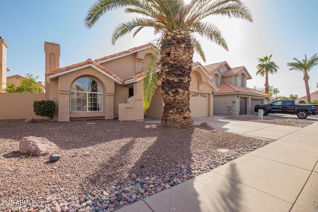 mediterranean / spanish home with driveway, a garage, a tile roof, fence, and stucco siding