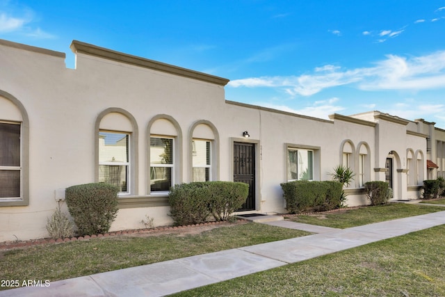 mediterranean / spanish-style home with a front yard and stucco siding