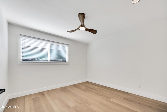 spare room featuring light wood-style floors, ceiling fan, and baseboards