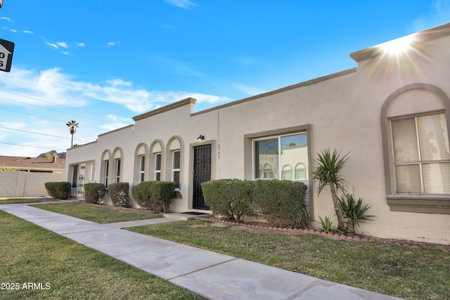 mediterranean / spanish-style home featuring a front yard and stucco siding