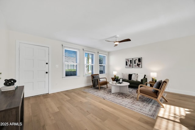 interior space with baseboards, a ceiling fan, and wood finished floors