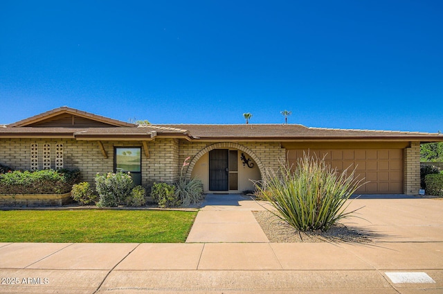 8355 E Via De Los Libros, Scottsdale, AZ 85258 - single story home with a garage, brick siding, concrete driveway, and a front lawn