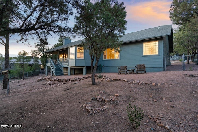 902 S Santa Fe Cir, Payson, AZ 85541 - back of property at dusk featuring stairway, a sunroom, a gate, and a chimney