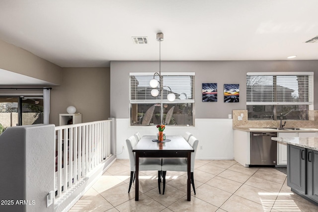 dining area featuring a wealth of natural light, a chandelier, and light tile patterned flooring