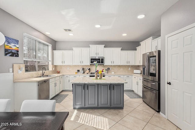 kitchen with stainless steel appliances, a center island, sink, and white cabinets