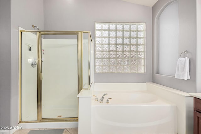 bathroom with tile patterned floors, vanity, independent shower and bath, and lofted ceiling