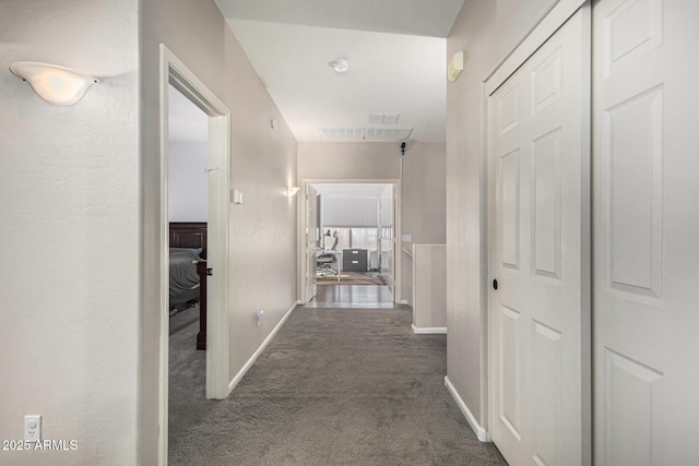 hallway featuring dark colored carpet