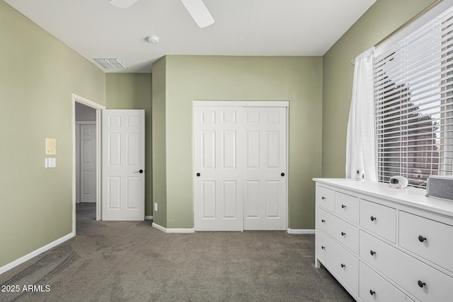 unfurnished bedroom with dark carpet and ceiling fan