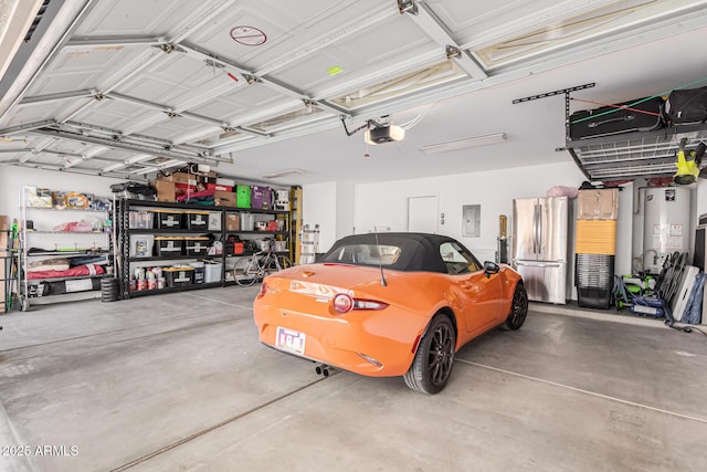 garage with a garage door opener, gas water heater, electric panel, and stainless steel refrigerator