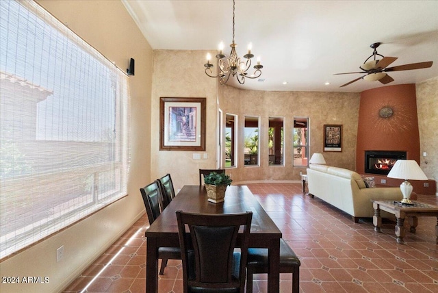 tiled dining space with a large fireplace and ceiling fan with notable chandelier