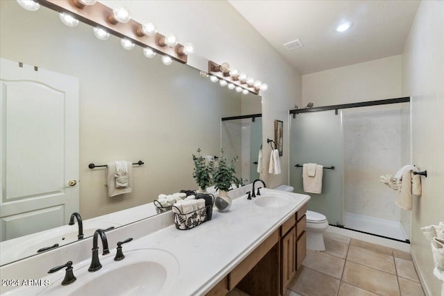 bathroom featuring vanity with extensive cabinet space, toilet, tile floors, walk in shower, and double sink