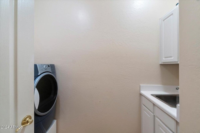 washroom featuring washer / dryer, cabinets, and sink