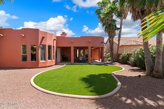 back of house featuring a patio and a yard