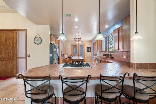 kitchen featuring kitchen peninsula, pendant lighting, and appliances with stainless steel finishes