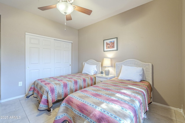 bedroom featuring a closet, baseboards, ceiling fan, and light tile patterned floors