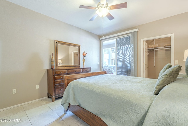 bedroom with a ceiling fan, light tile patterned floors, baseboards, a closet, and a spacious closet