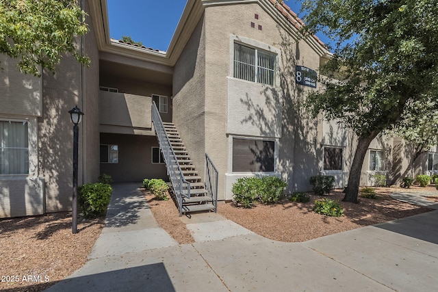 exterior space with stucco siding and stairway