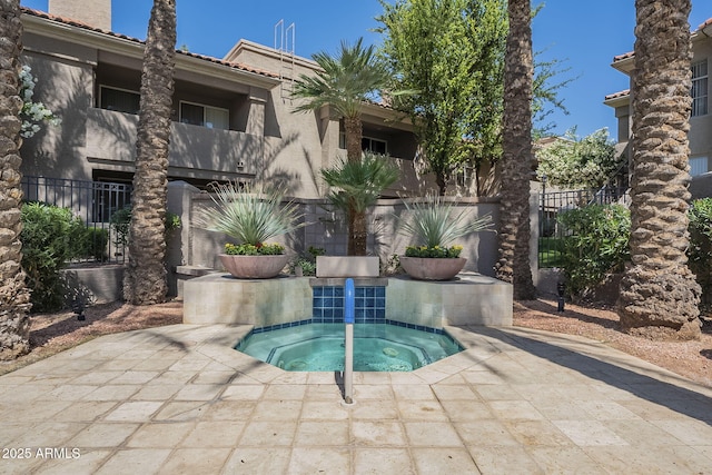 view of swimming pool with fence and a community hot tub