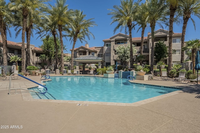 community pool featuring a gazebo, a residential view, and a patio area